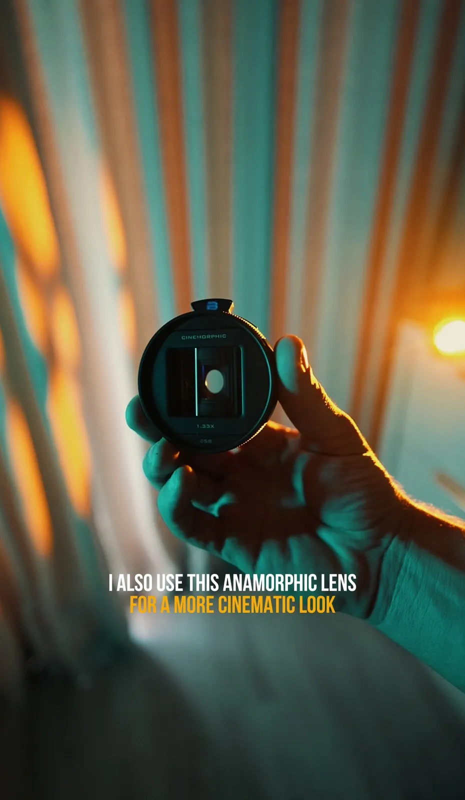 Hand holding Freewell 1.33x Cinemorphic anamorphic lens for iPhone